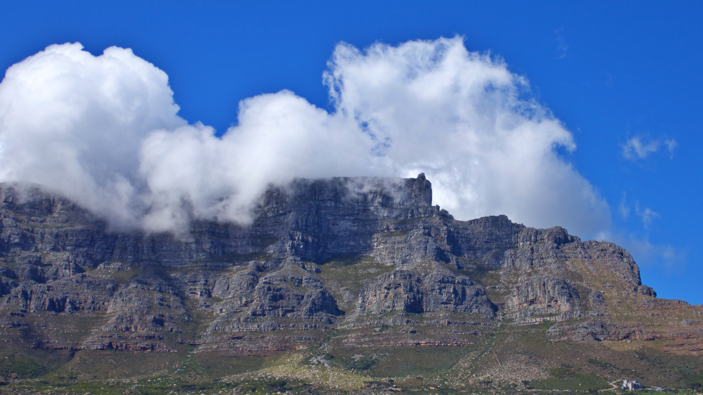 Table Mountain, shrouded in its signature 'tablecloth' of clouds, creates a mystical and captivating scene above Cape Town.